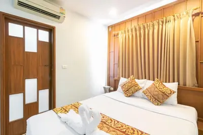 a hotel room with two beds and a window at Lotus Hotel Patong in Patong Beach