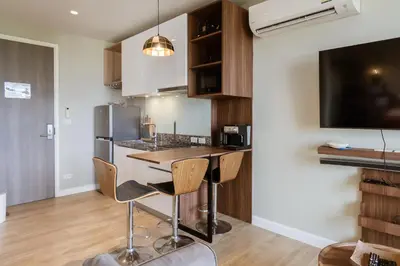 a kitchen with a table and chairs in a room at Mountain View Apartment - Bangtao in Kathu