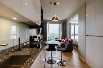 a kitchen with a table and a living room at Mountain View Apartment - Bangtao in Kathu