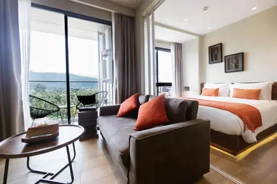 a hotel room with a bed and a couch at Mountain View Apartment - Bangtao in Kathu