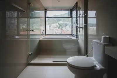 a bathroom with a toilet and a shower and a window at The deck patong 5 Star Apartment \u5df4\u4e1cThe Deck\u65e0\u8fb9\u9645\u6d77\u666f\u6cf3\u6c60\u9152\u5e97 in Patong Beach