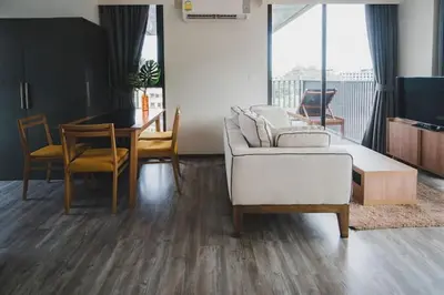 a living room with a couch and a table and chairs at The deck patong 5 Star Apartment \u5df4\u4e1cThe Deck\u65e0\u8fb9\u9645\u6d77\u666f\u6cf3\u6c60\u9152\u5e97 in Patong Beach