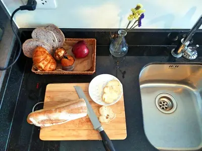 a counter with a cutting board with bread and a knife at The deck patong 5 Star Apartment \u5df4\u4e1cThe Deck\u65e0\u8fb9\u9645\u6d77\u666f\u6cf3\u6c60\u9152\u5e97 in Patong Beach