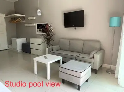 a living room with a couch and a tv at Thalassa Kata Beach in Kata Beach