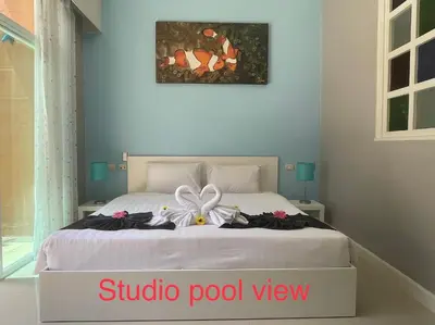a bedroom with a bed with a bow on it at Thalassa Kata Beach in Kata Beach
