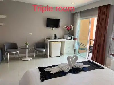 a hotel room with a bed with a table and chairs at Thalassa Kata Beach in Kata Beach