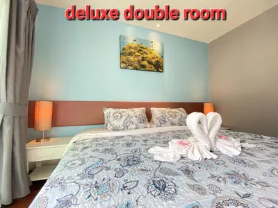 a bedroom with a bed with two towels on it at Thalassa Kata Beach in Kata Beach