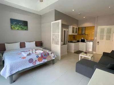 a bedroom with a bed and a living room at Thalassa Kata Beach in Kata Beach