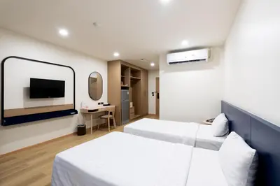 a hotel room with two beds and a flat screen tv at CA Hotel and Residence Phuket - SHA Extra Plus in Phuket Town