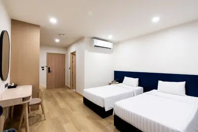 a hotel room with two beds and a desk at CA Hotel and Residence Phuket - SHA Extra Plus in Phuket Town