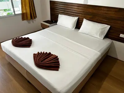 a bedroom with a bed with two towels on it at Coco's Guest House in Phi Phi Don