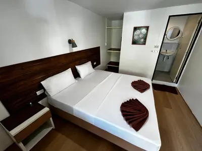 a bedroom with a large white bed with brown pillows at Coco's Guest House in Phi Phi Don