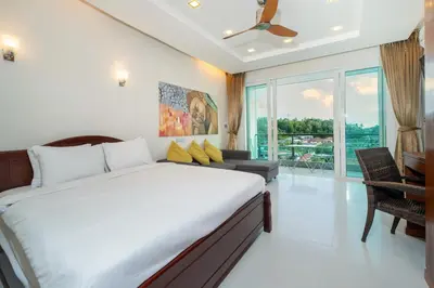 a bedroom with a bed and a couch and a window at Sea and Sky Condominium by Lofty in Karon Beach