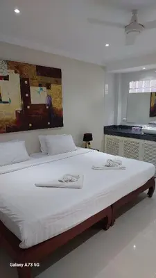 a bedroom with a large bed with white sheets at Siam Palm Residence in Patong Beach
