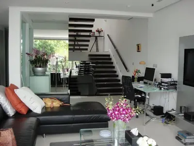 a living room with a black leather couch and a staircase at Siam Palm Residence in Patong Beach