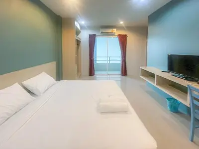 a large white bed in a room with a television at Hop On Phuket in Ban Bo Han