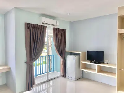 a living room with a television and a window at Hop On Phuket in Ban Bo Han