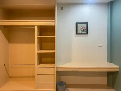 a closet with wooden shelves and a wall at Hop On Phuket in Ban Bo Han
