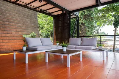 a patio with two couches and a coffee table at Koh Sirey Beachfront Pool Villa - 2 Bedrooms House in Phuket Town