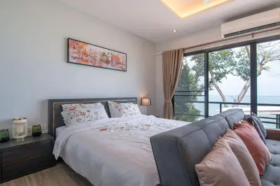 a bedroom with a bed and a large window at Koh Sirey Beachfront Pool Villa - 2 Bedrooms House in Phuket Town