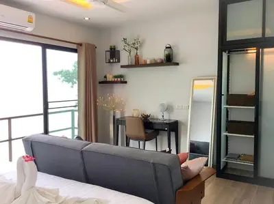 a bedroom with a couch and a table and a desk at Koh Sirey Beachfront Pool Villa - 2 Bedrooms House in Phuket Town