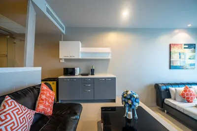 a living room with a couch and a table at The Ark at Veloche Group by Lofty in Karon Beach