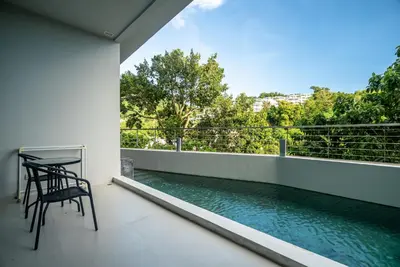 a balcony with a table and chairs and water at The Ark at Veloche Group by Lofty in Karon Beach