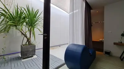 a room with potted plants and a blue chair at INNLUXPHUKET in Ban Laem Hin