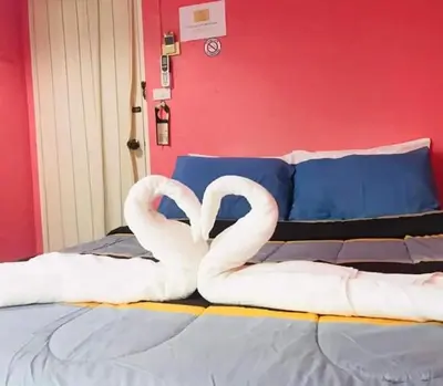 two white swans making a heart on a bed at Sea Shell Hut in Phi Phi Don