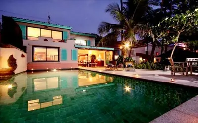 a house with a swimming pool in front of a house at Goodwill Beach House in Patong Beach