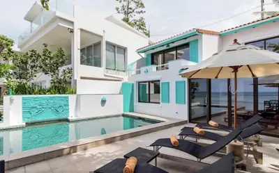 a villa with a swimming pool and a house at Goodwill Beach House in Patong Beach