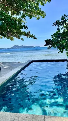 a swimming pool with a view of the water at Goodwill Beach House in Patong Beach