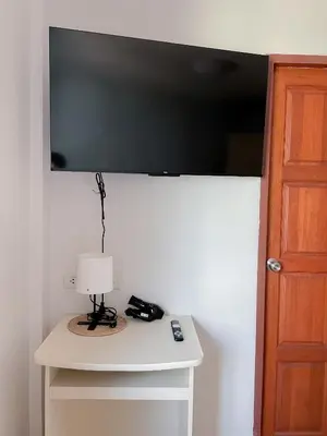 a television on a wall above a table with a lamp at The 4 Blocks at Kata noi in Kata Beach