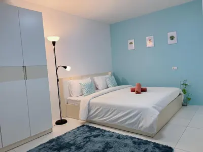 a bedroom with a white bed with a blue wall at The 4 Blocks at Kata noi in Kata Beach