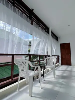 a balcony with two white chairs and a table at The 4 Blocks at Kata noi in Kata Beach