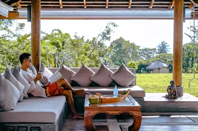 a man sitting on a couch in a living room at VILLA DIVA STAR in Ko Yao Noi