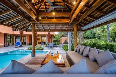 an outdoor living room with a couch and a swimming pool at VILLA DIVA STAR in Ko Yao Noi