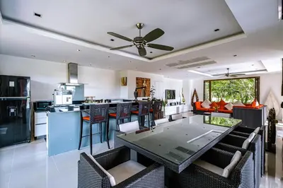 a kitchen and living room with a table and chairs at VILLA DIVA STAR in Ko Yao Noi