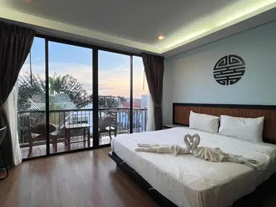 a bedroom with a large bed and a balcony at Z&Z House in Rawai Beach