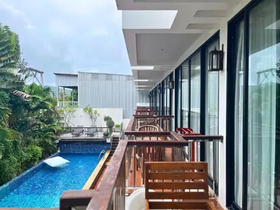 a balcony with wooden benches and a swimming pool at Z&Z House in Rawai Beach