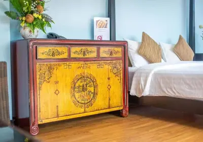 a wooden dresser sitting next to a bed at Z&Z House in Rawai Beach