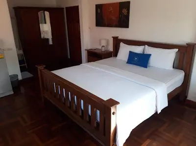 a bedroom with a large bed with a blue pillow on it at The Pavillon by The Pace Phuket Boutique Resort in Rawai Beach