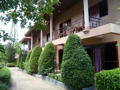 a building with a row of trees in front of it at The Pavillon by The Pace Phuket Boutique Resort in Rawai Beach
