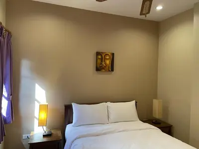 a bedroom with a bed with a mask on the wall at The Pavillon by The Pace Phuket Boutique Resort in Rawai Beach