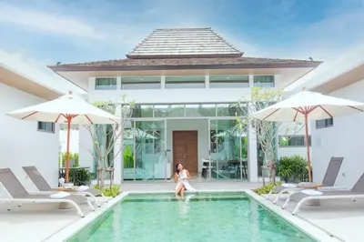 a woman sitting in the swimming pool of a villa at Ananas villa Shambala grand Cherng Talay in Bang Tao Beach