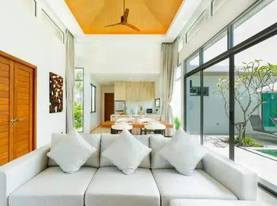 a living room with a white couch with pillows at Ananas villa Shambala grand Cherng Talay in Bang Tao Beach