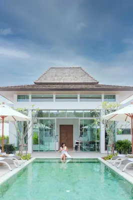 a woman sitting in a swimming pool in a house at Ananas villa Shambala grand Cherng Talay in Bang Tao Beach