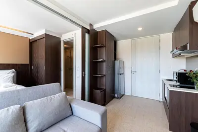 a living room with a couch and a kitchen at Aristo 1 Phuket by RESAVA in Phuket Town