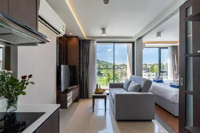 a living room with a couch and a large window at Aristo 1 Phuket by RESAVA in Phuket Town