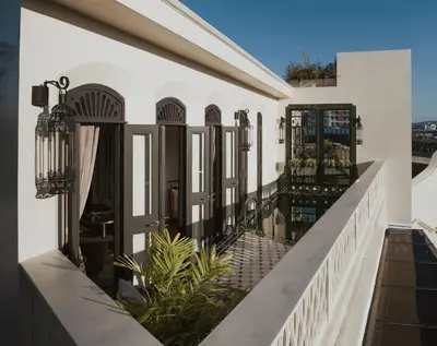 a balcony with black doors on a white house at Hotel Verdigris in Phuket Town